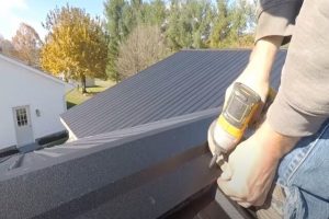 Worker installing a metal roof on a residential roof.