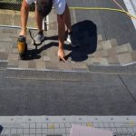 JP Kitchener Roofing employee installing shingles on a roof.