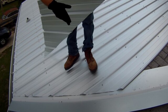 Metal roof installation by Kitchener Roofing worker.